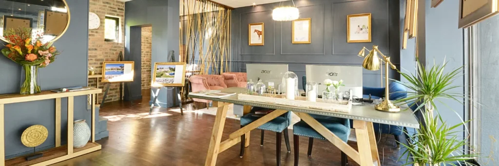 Modern Fine & Country Chiswick estate agency office interior with navy walls, gold accents, pink velvet seating, and contemporary decor.