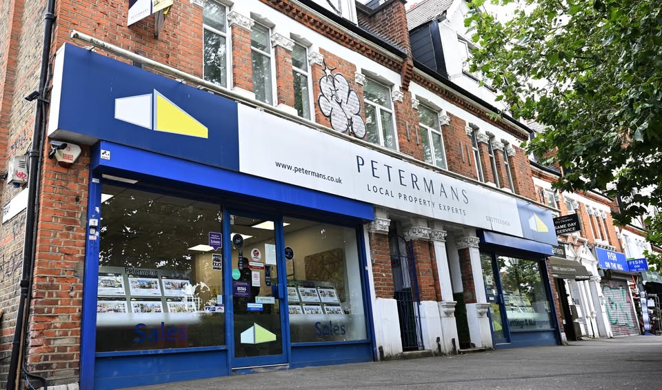 Street view of the Petermans Estate Agents office in Herne Hill, with branding visible on the signage and property listings displayed in the windows.