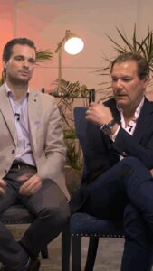 Two estate agents filming personal branding videos in the Digital Sparks studio, seated in a styled set designed for professional content creation.