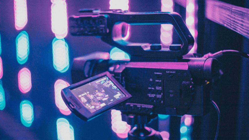 Professional video camera recording in a studio with neon lights, symbolizing the power of video to grow your property brand on social media.
